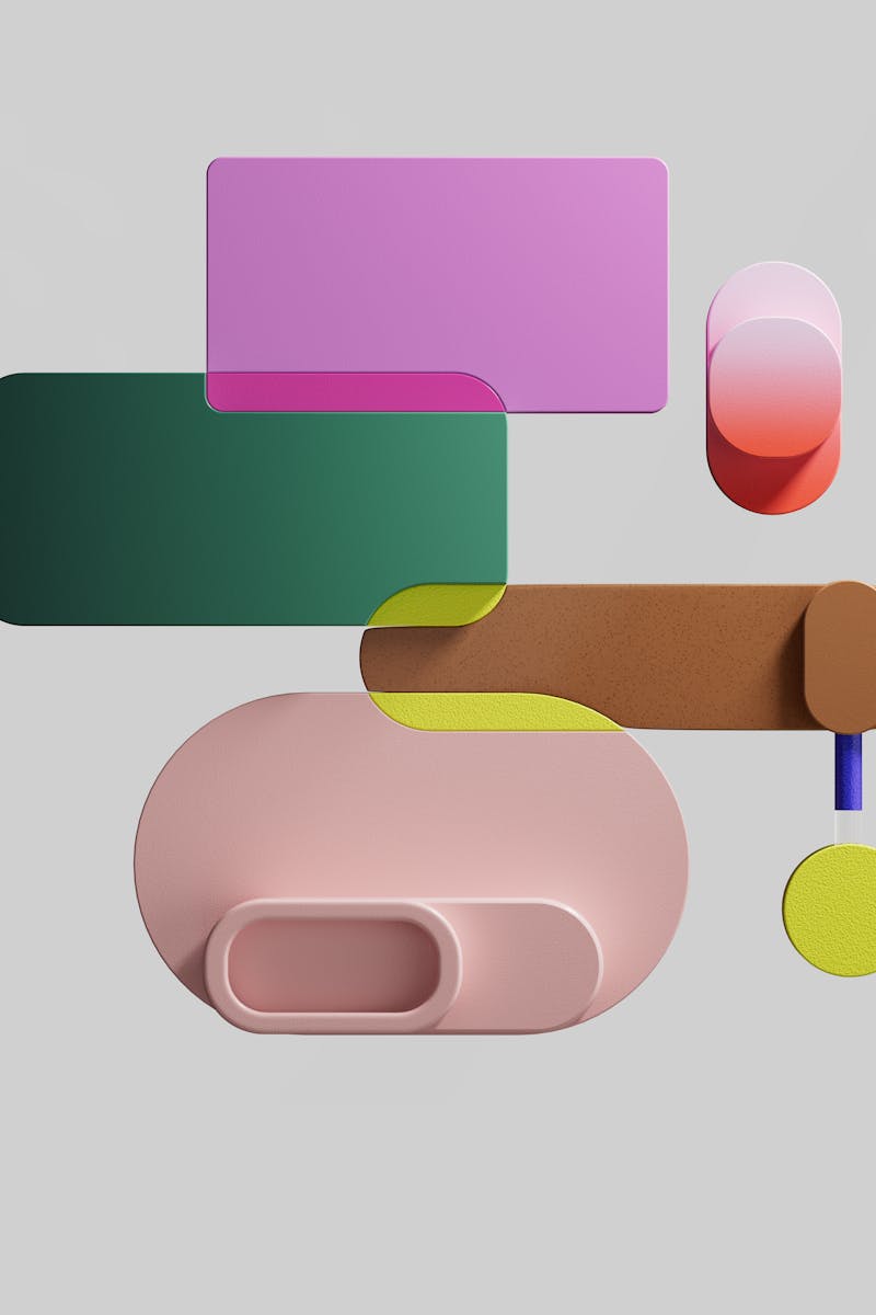 Colorful abstract 3D shapes arranged on a soft gray background, evoking modern art.