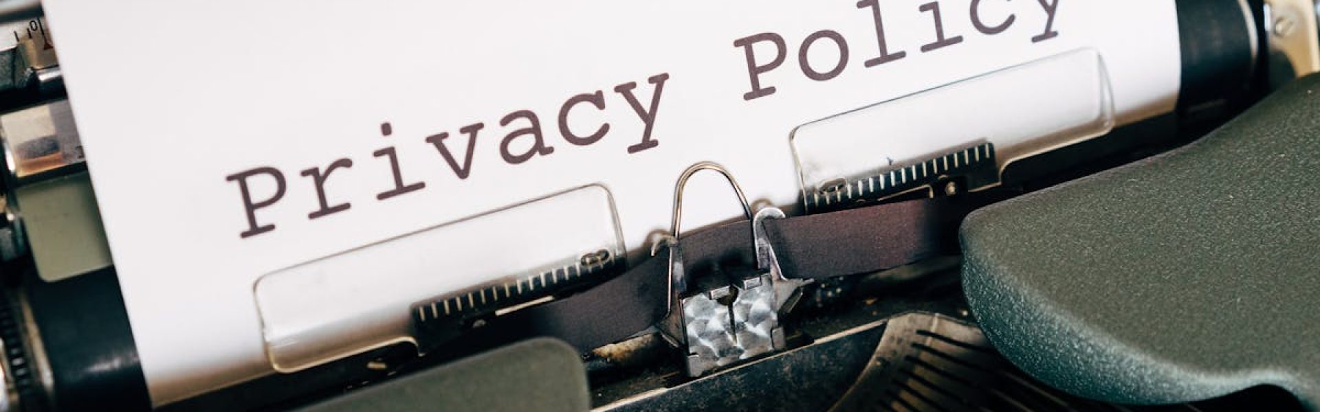 A vintage typewriter writing 'Privacy Policy' on paper, capturing an old-school conceptual theme.